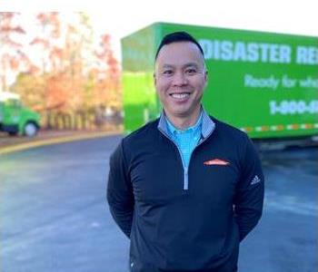 Male employee in front of green SERVPRO truck