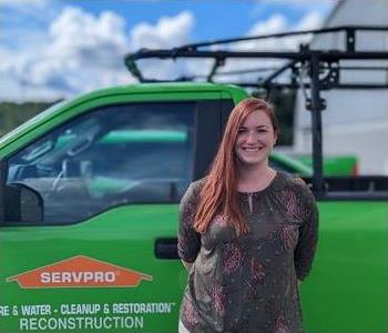 Female Employee in front of green servpro truck